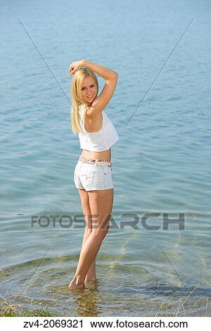 Young woman at the shore of a lake, Austria. View Large Photo Image Stock Image - Young woman at the shore of a lake, Austria.. Fotosearch