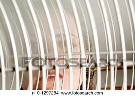 Young woman behind an electric fan View Large Photo Image Picture - Young woman behind an electric fan. Fotosearch