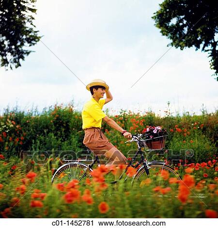 Young woman biking on country road View Large Photo Image Stock Image - Young woman biking on country road. Fotosearch
