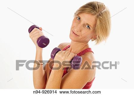 Young woman, blonde, exercising with weights in the gym to get fit. View Large Photo Image Picture - Young woman, blonde, exercising with weights in the gym to get fit.. Fotosearch