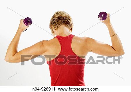 Young woman, blonde, exercising with weights in the gym to get fit. View Large Photo Image Stock Image - Young woman, blonde, exercising with weights in the gym to get fit.. Fotosearch