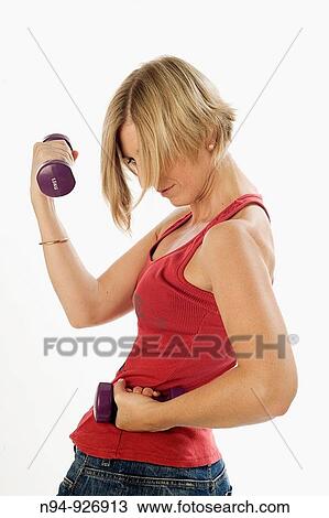 Young woman, blonde, exercising with weights in the gym to get fit. View Large Photo Image Stock Image - Young woman, blonde, exercising with weights in the gym to get fit.. Fotosearch