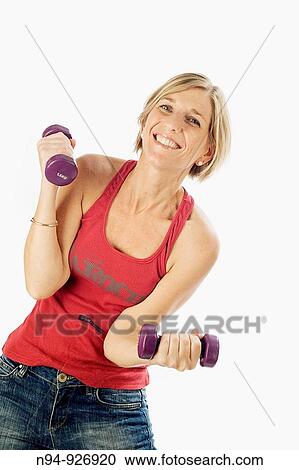 Young woman, blonde, exercising with weights in the gym to get fit. View Large Photo Image Stock Image - Young woman, blonde, exercising with weights in the gym to get fit.. Fotosearch