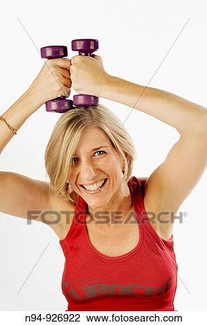 Young woman, blonde, exercising with weights in the gym to get fit. View Large Photo Image Stock Image - Young woman, blonde, exercising with weights in the gym to get fit.. Fotosearch
