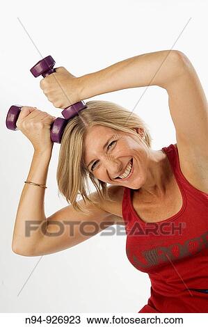 Young woman, blonde, exercising with weights in the gym to get fit. View Large Photo Image Stock Image - Young woman, blonde, exercising with weights in the gym to get fit.. Fotosearch