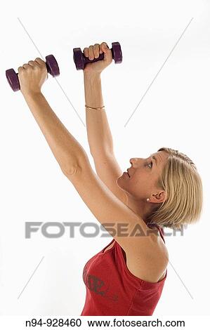 Young woman, blonde, exercising with weights in the gym to get fit. View Large Photo Image Stock Image - Young woman, blonde, exercising with weights in the gym to get fit.. Fotosearch