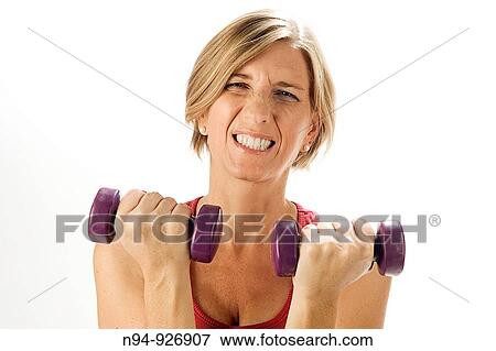 Young woman, blonde, exercising with weights in the gym to get fit. View Large Photo Image Stock Photo - Young woman, blonde, exercising with weights in the gym to get fit.. Fotosearch