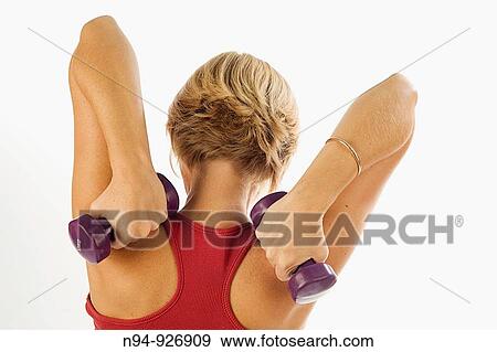 Young woman, blonde, exercising with weights in the gym to get fit. View Large Photo Image Stock Photo - Young woman, blonde, exercising with weights in the gym to get fit.. Fotosearch