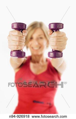 Young woman, blonde, exercising with weights in the gym to get fit. View Large Photo Image Stock Photo - Young woman, blonde, exercising with weights in the gym to get fit.. Fotosearch