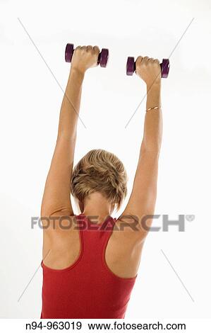 Young woman, blonde, exercising with weights in the gym to get fit. View Large Photo Image Stock Photo - Young woman, blonde, exercising with weights in the gym to get fit.. Fotosearch