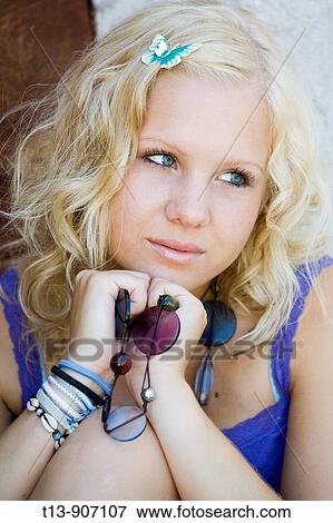 Stock Photo - Young woman blonde portrait with small peg butterfly in her hair. Fotosearch