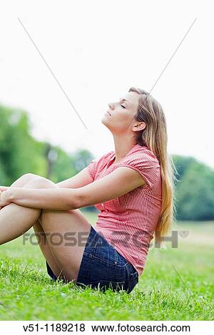 Young woman blonde sitting in the park relaxing View Large Photo Image Stock Photo - Young woman blonde sitting in the park relaxing. Fotosearch