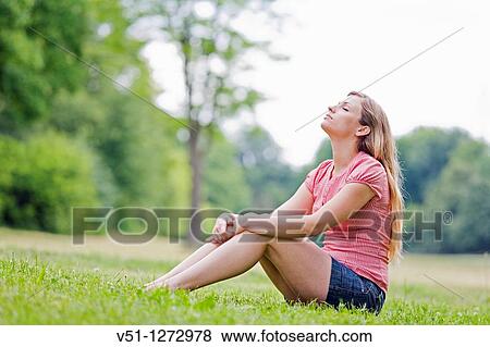 Young woman blonde sitting in the park relaxing View Large Photo Image Stock Photo - Young woman blonde sitting in the park relaxing. Fotosearch