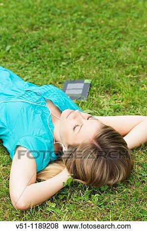 Young woman blonde woman lying down on the park relaxing View Large Photo Image Stock Photo - Young woman blonde woman lying down on the park relaxing. Fotosearch