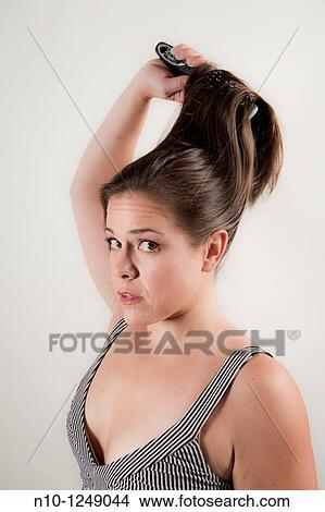 Picture - Young woman brushing her hair. Fotosearch