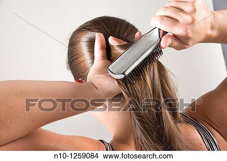 Picture - Young woman brushing her hair. Fotosearch