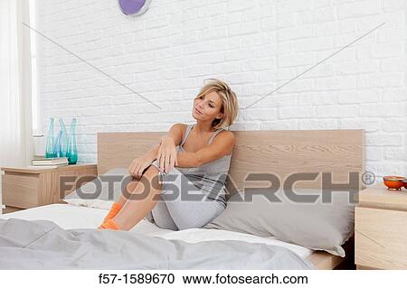 Young woman chilling out on her bed View Large Photo Image Stock Image - Young woman chilling out on her bed. Fotosearch