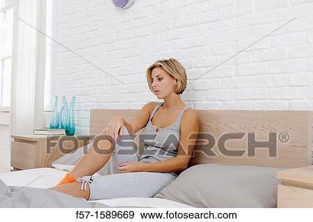 Young woman chilling out on her bed watching TV View Large Photo Image Stock Photo - Young woman chilling out on her bed watching TV. Fotosearch