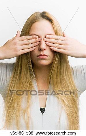 Stock Photo - young woman covering her eyes with her hands. Fotosearch