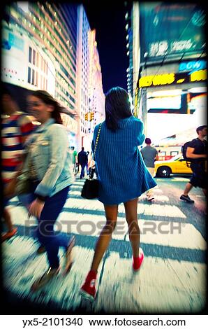Young woman crossing street at Times Square in New York. View Large Photo Image Stock Image - Young woman crossing street at Times Square in New York.. Fotosearch