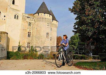 young woman cycling in front of the Castle St-Jean, Nogent-le-Rotrou, Parc naturel regional du Perche, Eure & Loir department, region Centre, France, Europe. View Large Photo Image Stock Image - young woman cycling in front of the Castle St-Jean, Nogent-le-Rotrou, Parc naturel regional du Perche, Eure & Loir department, region Centre, France, Europe.. Fotosearch