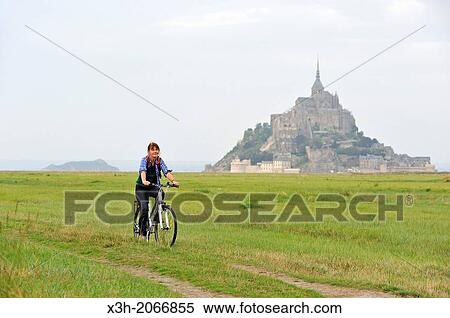 young woman cycling in the bay of Mont Saint-Michel, Manche department, Low Normandy region, France, Europe. View Large Photo Image Stock Photography - young woman cycling in the bay of Mont Saint-Michel, Manche department, Low Normandy region, France, Europe.. Fotosearch