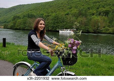young woman cycling on cycle lane along the Meuse River at Haybes, Ardennes department, Champagne-Ardenne region of northeasthern France, Europe. View Large Photo Image Stock Image - young woman cycling on cycle lane along the Meuse River at Haybes, Ardennes department, Champagne-Ardenne region of northeasthern France, Europe.. Fotosearch