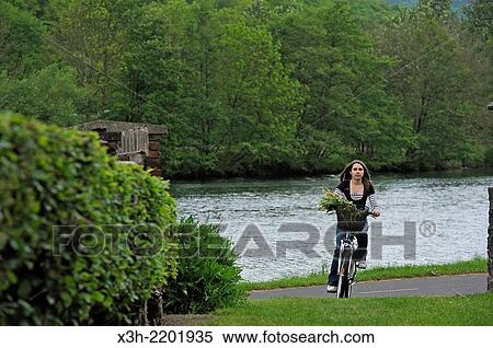 young woman cycling on cycle lane along the Meuse River at Haybes, Ardennes department, Champagne-Ardenne region of northeasthern France, Europe. View Large Photo Image Stock Photography - young woman cycling on cycle lane along the Meuse River at Haybes, Ardennes department, Champagne-Ardenne region of northeasthern France, Europe.. Fotosearch