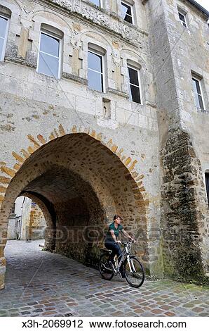 young woman cycling under the Saint-Denis Gate, Mortagne-au-Perche, Regional Natural Park of Perche, Orne department, Lower Normandy region, France, Western Europe. View Large Photo Image Stock Image - young woman cycling under the Saint-Denis Gate, Mortagne-au-Perche, Regional Natural Park of Perche, Orne department, Lower Normandy region, France, Western Europe.. Fotosearch