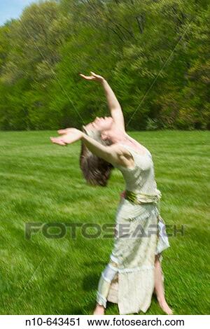 Young woman dancing on the grass at a park. View Large Photo Image Stock Image - Young woman dancing on the grass at a park.. Fotosearch