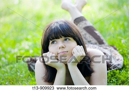 Young woman daydreaming on grass View Large Photo Image Stock Image - Young woman daydreaming on grass. Fotosearch
