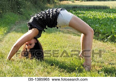 Stock Photography - Young woman doing a cartwheel. Fotosearch