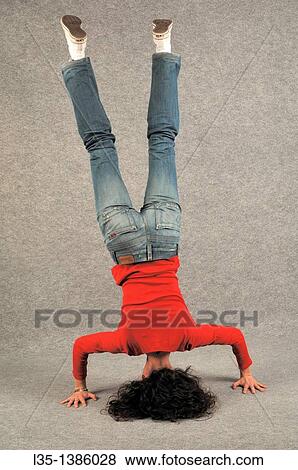 Stock Photo - Young woman doing a headstand. Fotosearch