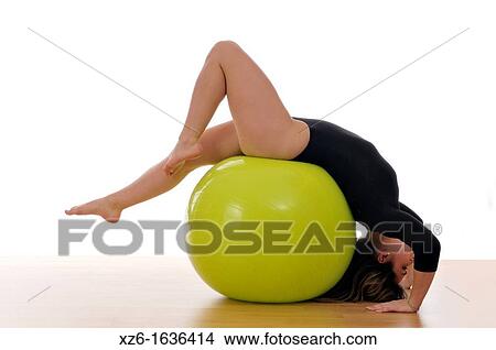 Picture - young woman doing exercise, gymnastics, with a large green ball, giant ball. Fotosearch