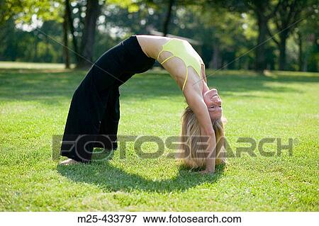Young woman doing gymnastics in park View Large Photo Image Stock Photo - Young woman doing gymnastics in park. Fotosearch