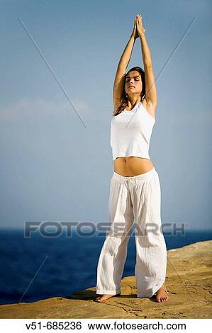Young woman doing yoga by the sea View Large Photo Image Stock Photograph - Young woman doing yoga by the sea. Fotosearch