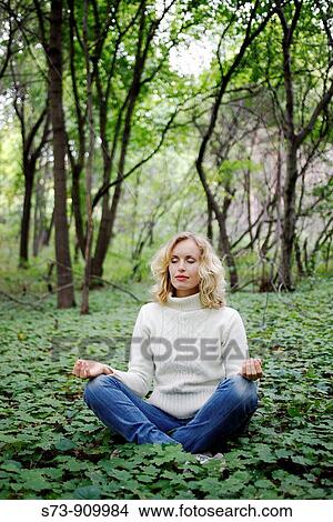 Young woman doing yoga in a russian forest, Molodeskiy Kurgan National Park, Samara Region, Russian Federation View Large Photo Image Picture - Young woman doing yoga in a russian forest, Molodeskiy Kurgan National Park, Samara Region, Russian Federation. Fotosearch