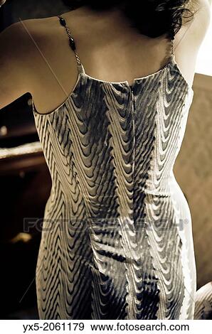 Stock Photo - Young woman dressing in front of a vanity mirror.. Fotosearch