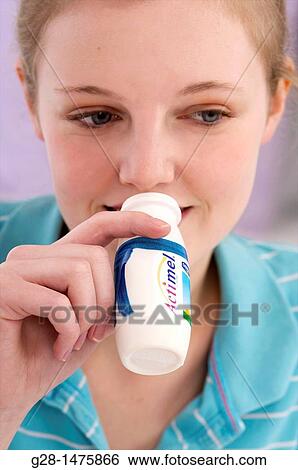 Stock Photograph - young woman drinking a bottle of pro biotic live yogurt for energy. Fotosearch