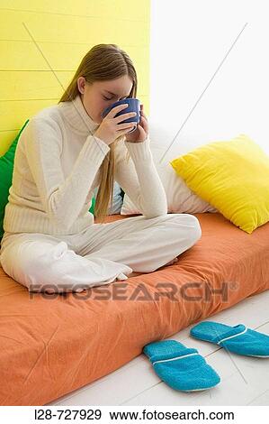 Young woman drinking a cup of tea or coffee View Large Photo Image Stock Photo - Young woman drinking a cup of tea or coffee. Fotosearch