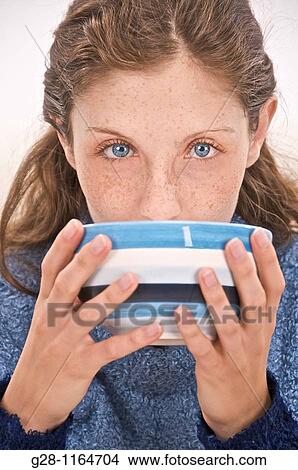 Picture - young woman drinking from a bowl. Fotosearch