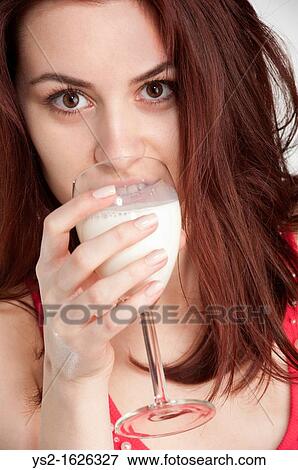 Stock Photo - Young woman drinking milk from a wine glass. Fotosearch
