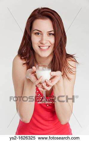 Stock Photography - Young woman drinking milk from a wine glass. Fotosearch