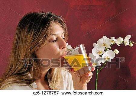 Stock Photo - Young woman drinking orange juice. Fotosearch