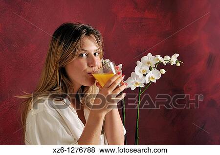 Young woman drinking orange juice View Large Photo Image Stock Photo - Young woman drinking orange juice. Fotosearch