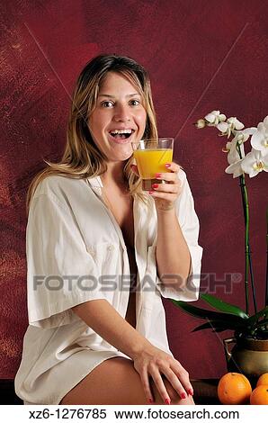 Stock Photography - Young woman drinking orange juice. Fotosearch