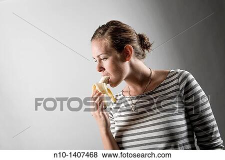 Young woman eating a banana View Large Photo Image Stock Photo - Young woman eating a banana. Fotosearch