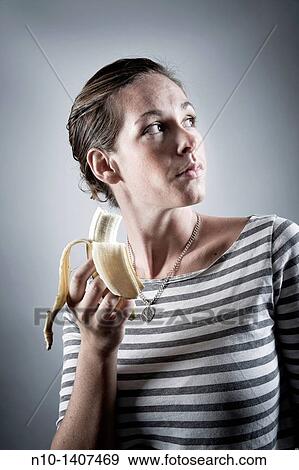 Young woman eating a banana View Large Photo Image Stock Photo - Young woman eating a banana. Fotosearch