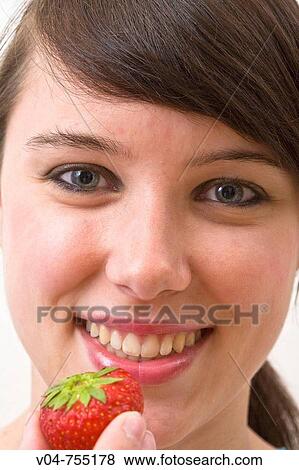 Young woman eating a strawberry View Large Photo Image Stock Photo - Young woman eating a strawberry. Fotosearch
