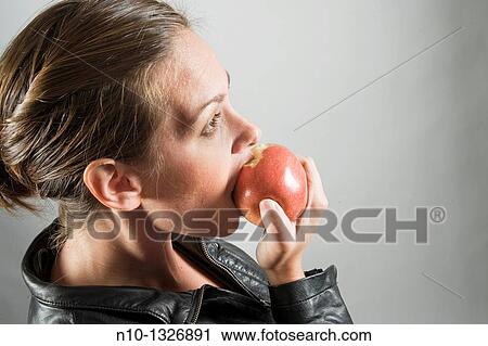 Young woman eating an apple View Large Photo Image Stock Image - Young woman eating an apple. Fotosearch